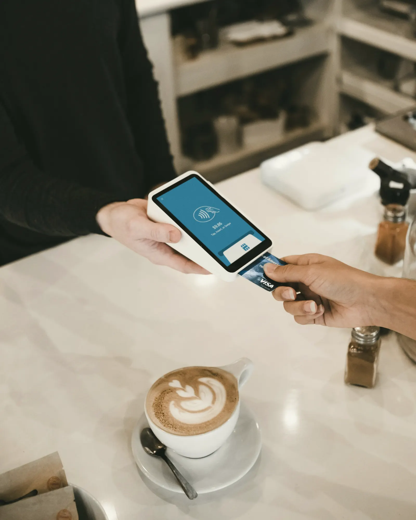 A customer paying with a phone at a café counter